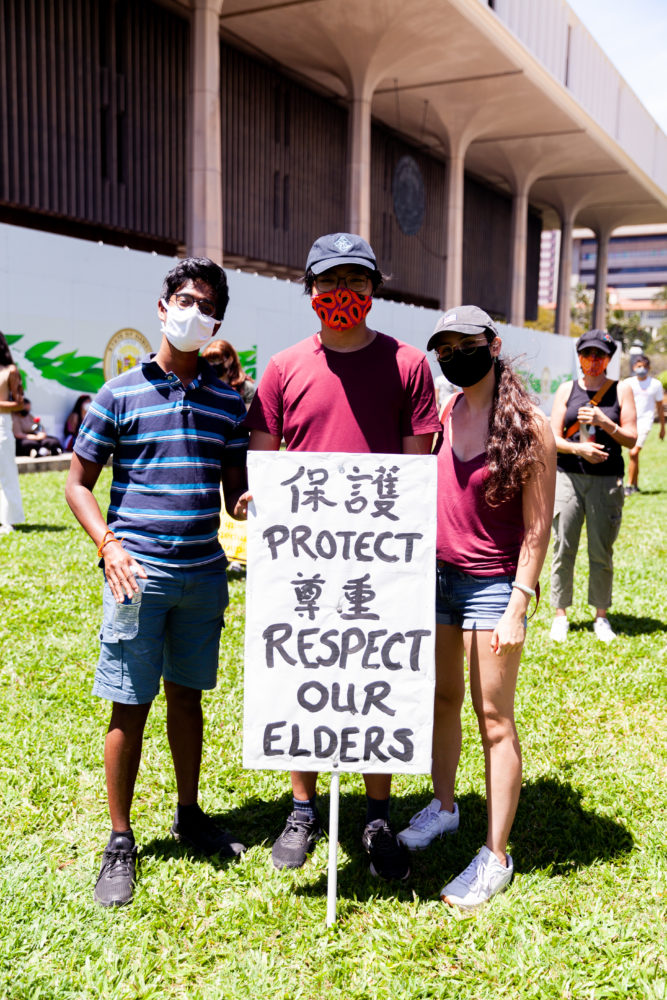 Group of demonstrators with a sign saying "Protect Respect Our Elders"
