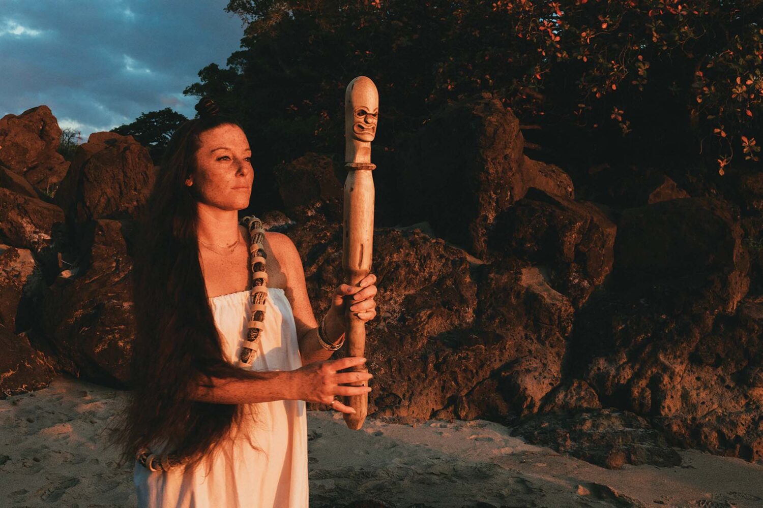 ceremonialist holding a hawaiian ceremonial wooden sculpture