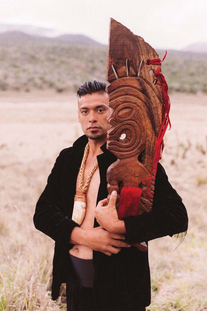 modern ceremonial practices, a man holding a Hawaiian sculpture
