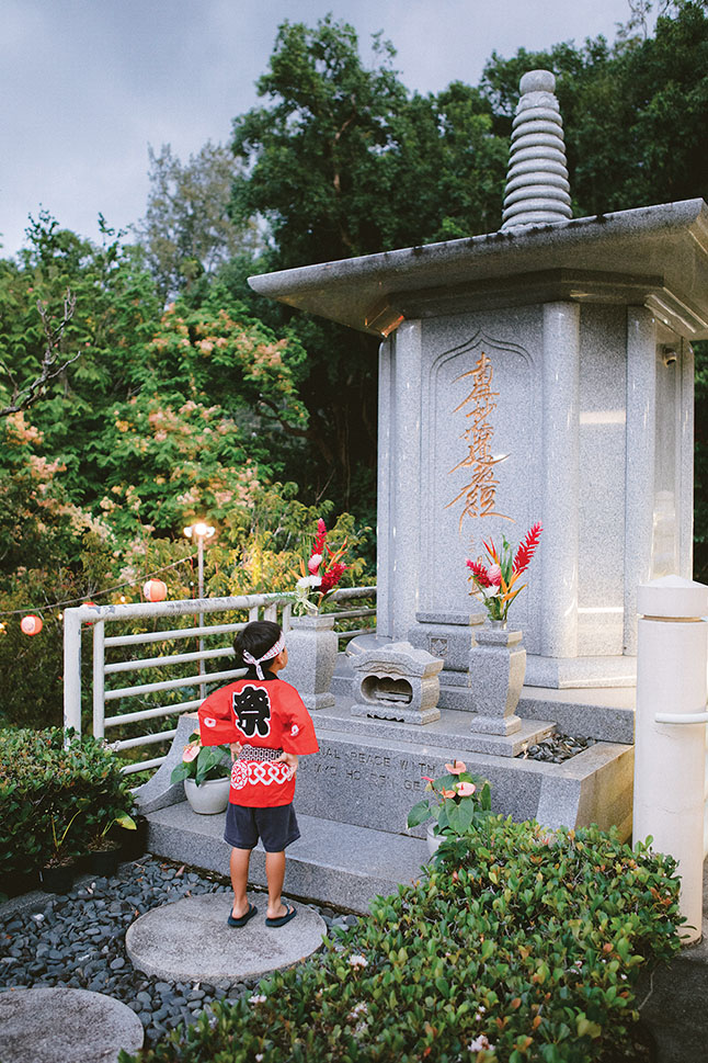 a child standing in front of a grave