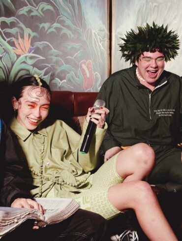 a group of people sitting on a couch with microphones