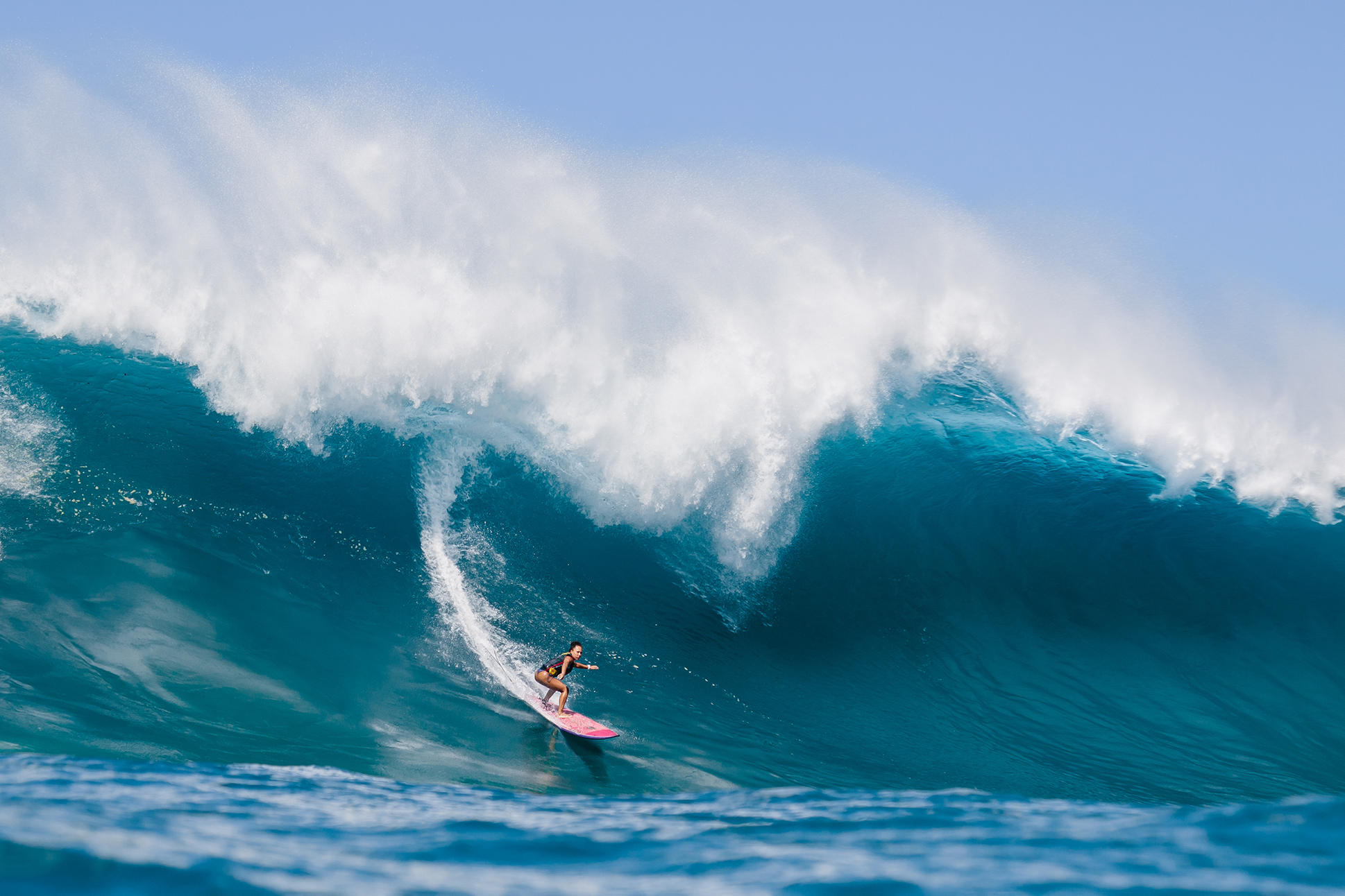female surfer riding massive wave in Hawaii