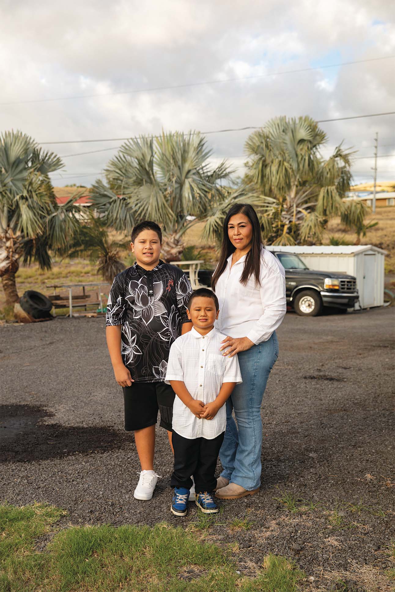 three people standing on a driveway on their property in Kailapa